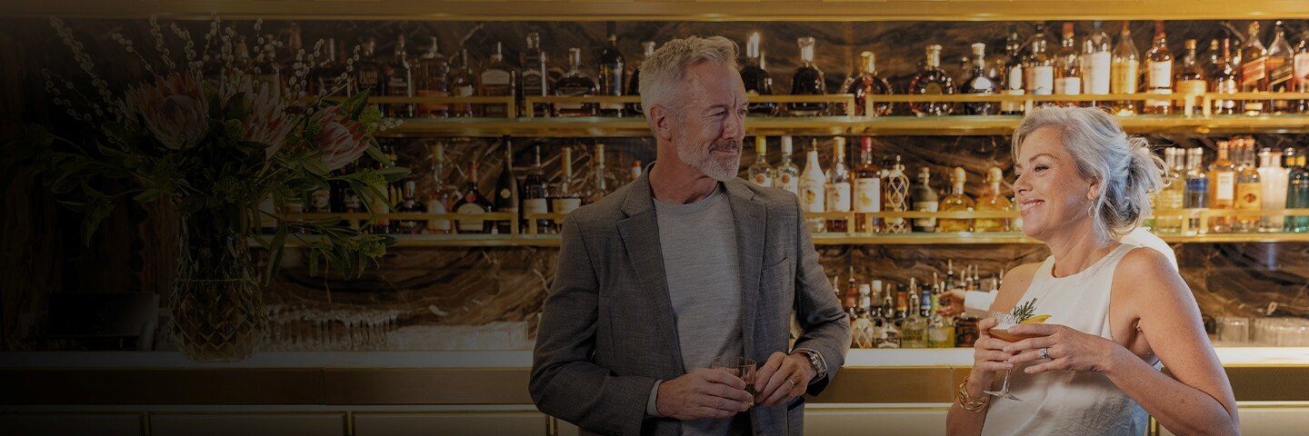 couple laughing with drinks in their hand aboard a Regent ship