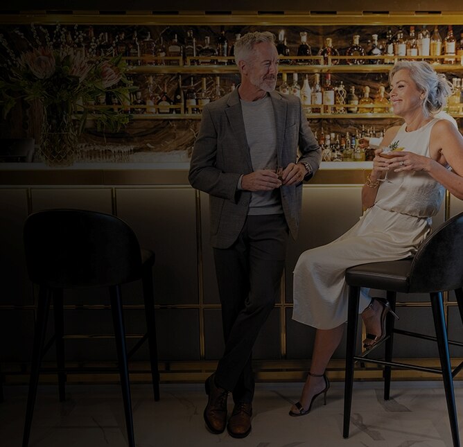 couple laughing with drinks in their hand aboard a Regent ship