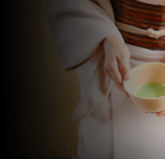 Geisha holding a cup of green matcha tea