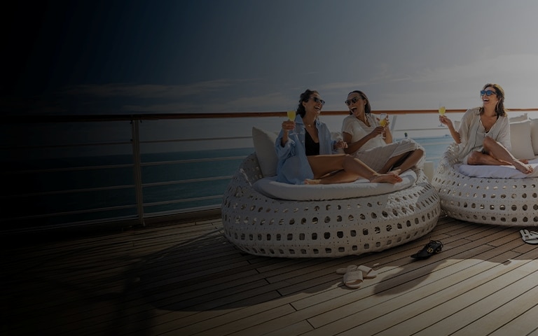 Group of friends laughing and lounging aboard a Regent luxury cruise