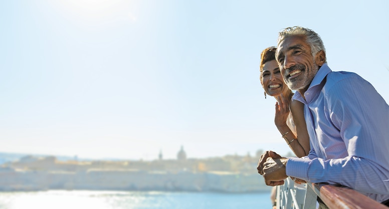 Couple enjoying the views from their luxury cruise ship aboard The World's Most Luxurious Fleet