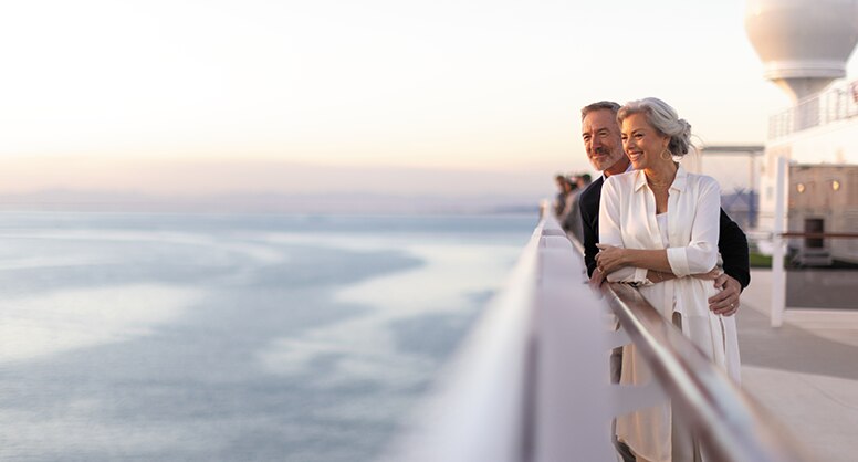 Couple looking out to the sea aboard a luxury cruise ship with Regent Seven Seas Cruises