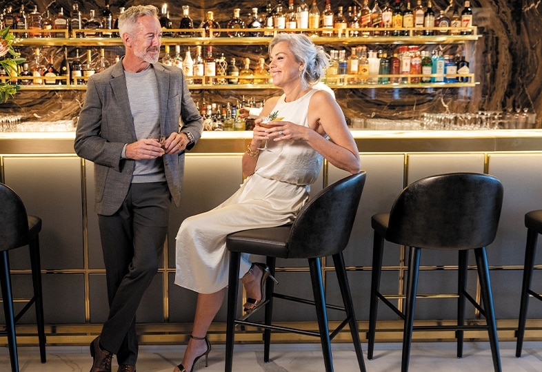 Couple lounging at a bar on a luxury cruise ship