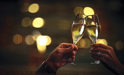 Two champagne glasses being clinked